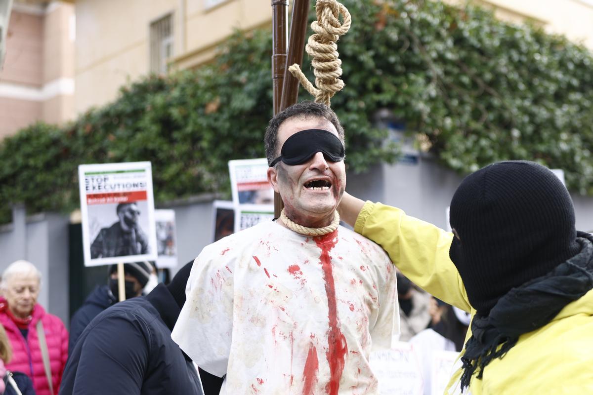 Varios manifestantes simulan una ejecución durante la manifiestación en frente de la embajada de Irán este sábado en Madrid.
