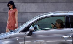 Una mujer habla con el móvil en el coche.