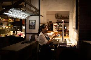 Una camarera sirve una cerveza en el interior de un bar.