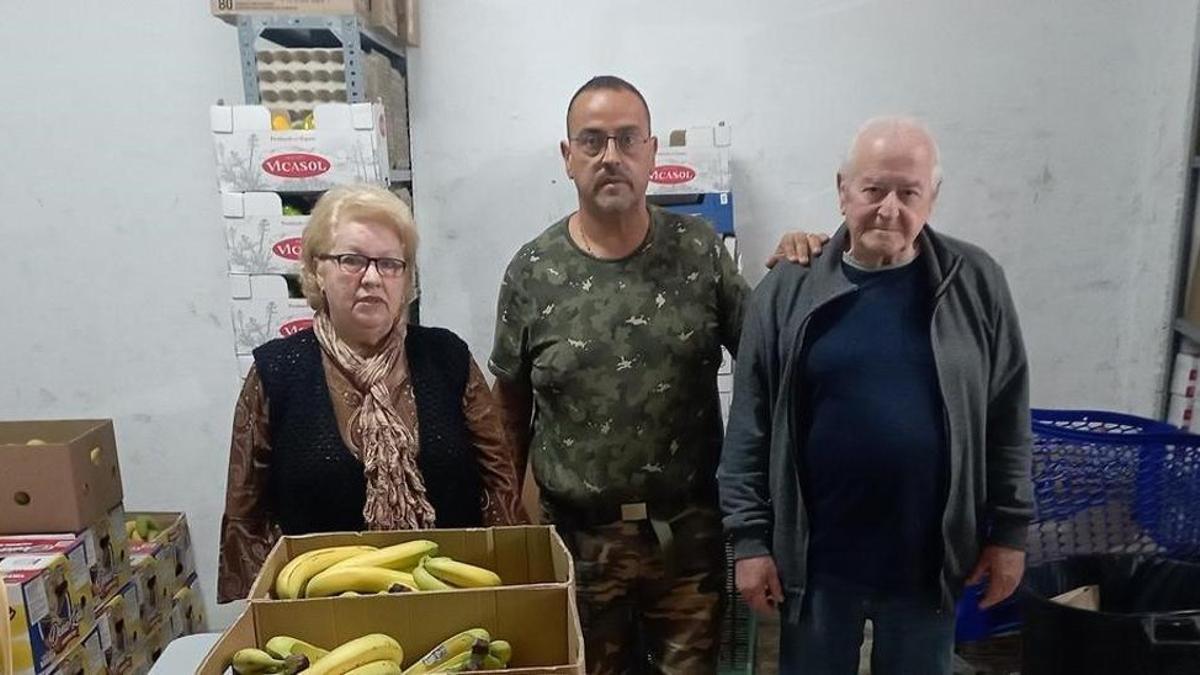 El presidente vecinal, Curro López, ayer junto a Ana y Octavio, dos pensionistas que reciben alimentos del colectivo.