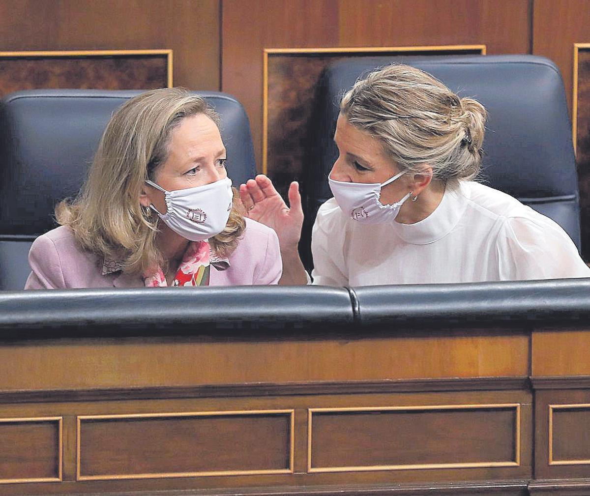 Las vicepresidentas primera, Nadia Calviño, y segunda, Yolanda Díaz, conversan durante una sesión de control al Gobierno en el Congreso